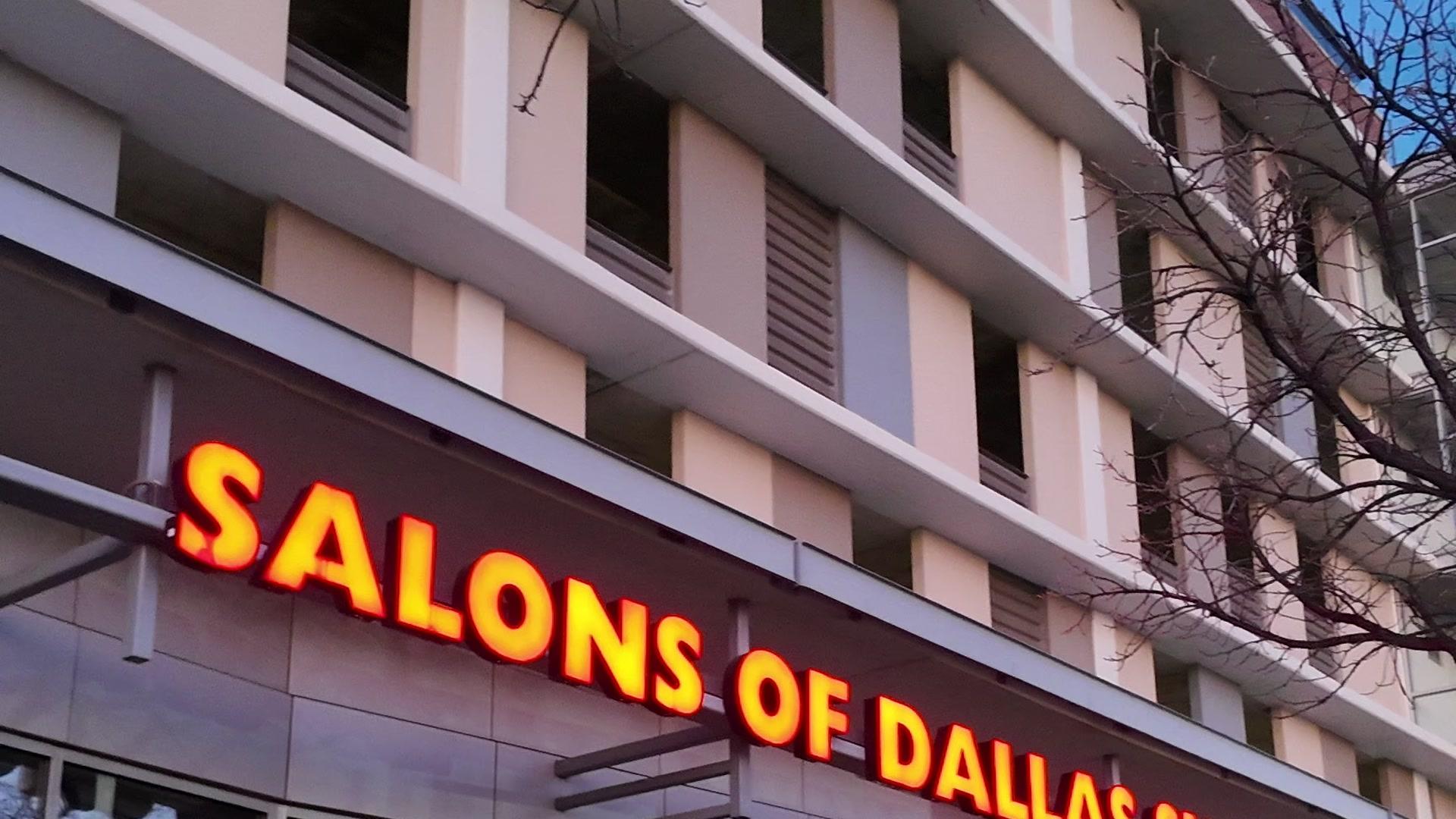 Salons of Dallas neon sign close-up at dusk
