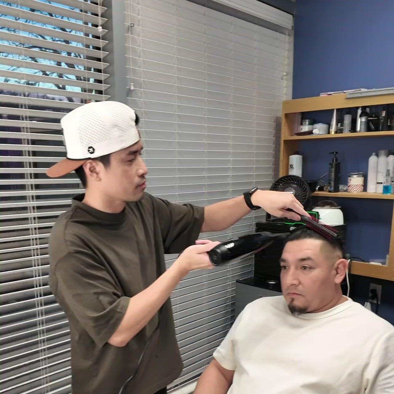 Barber styling a client in the blue-walled suite