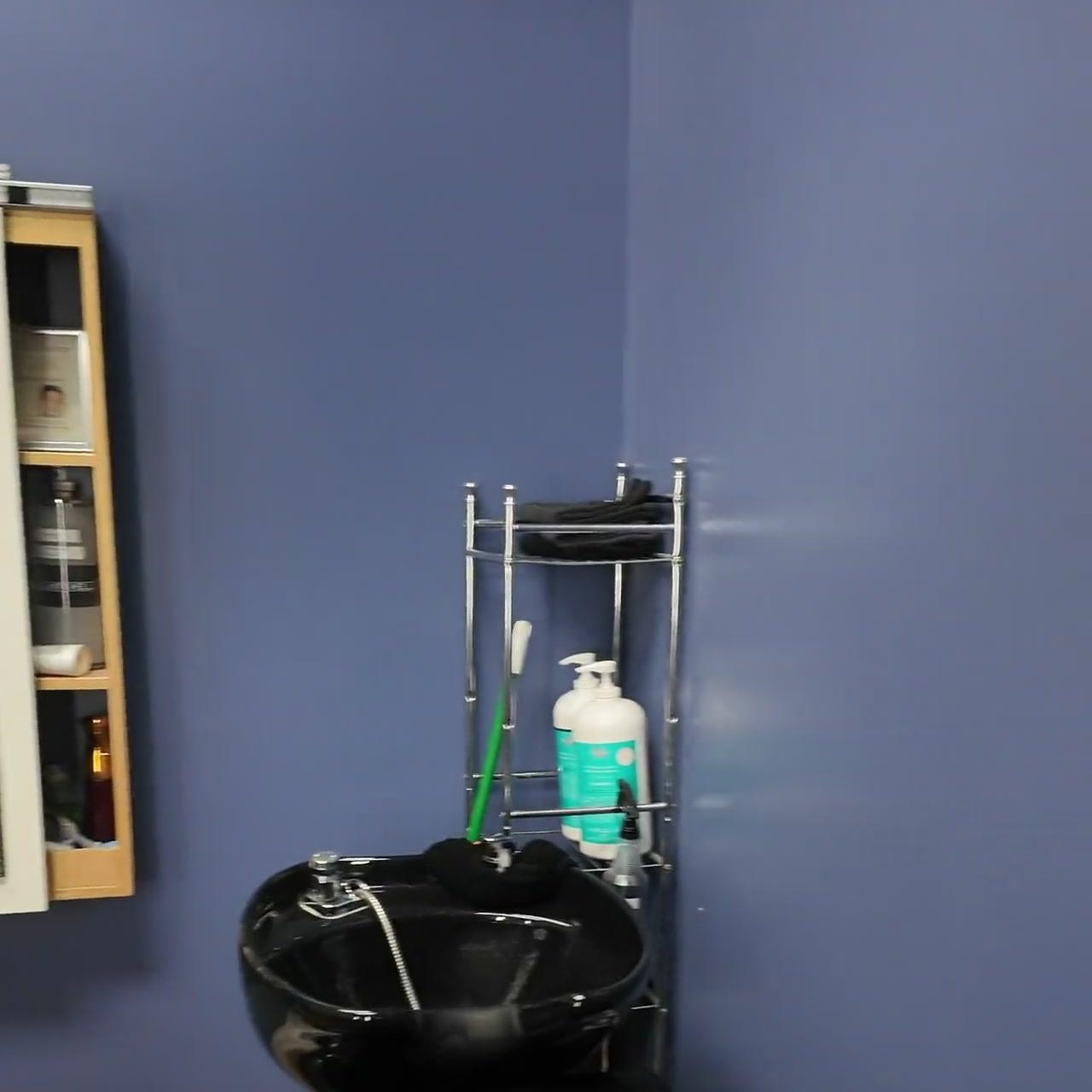 Blue-walled barber suite with professional shampoo station